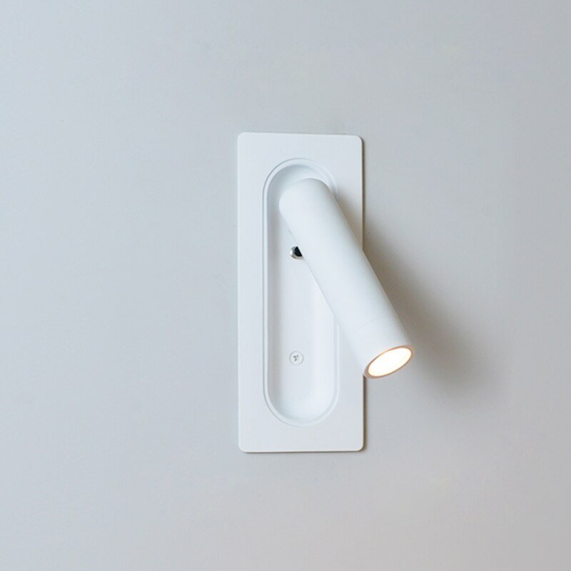 Minimalistisk vegglampe ved nattbord