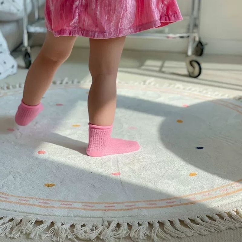 Morbido tappetino bianco per la cameretta dei bambini con dettagli a pois e nappe - rosa e nero