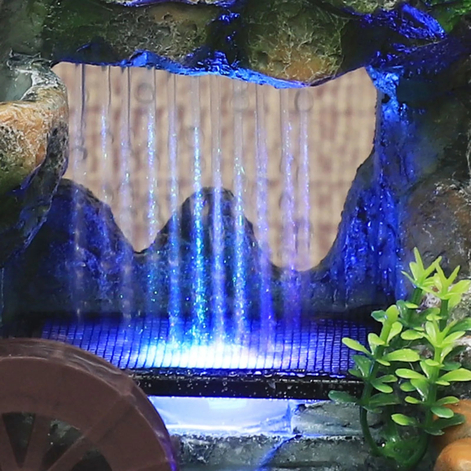 Beleuchteter Wasserfallbrunnen mit Steingarten und Baumschmuck