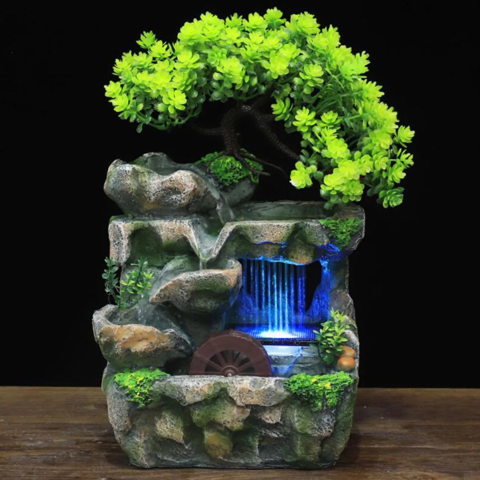 Fontana a cascata illuminata con giardino roccioso e ornamento per albero