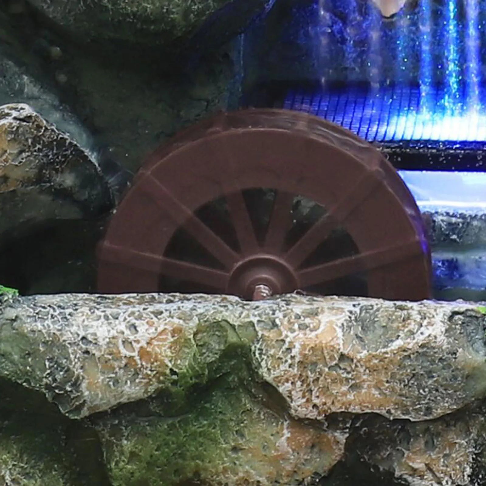 Fuente de cascada iluminada con rocalla y adorno de árbol