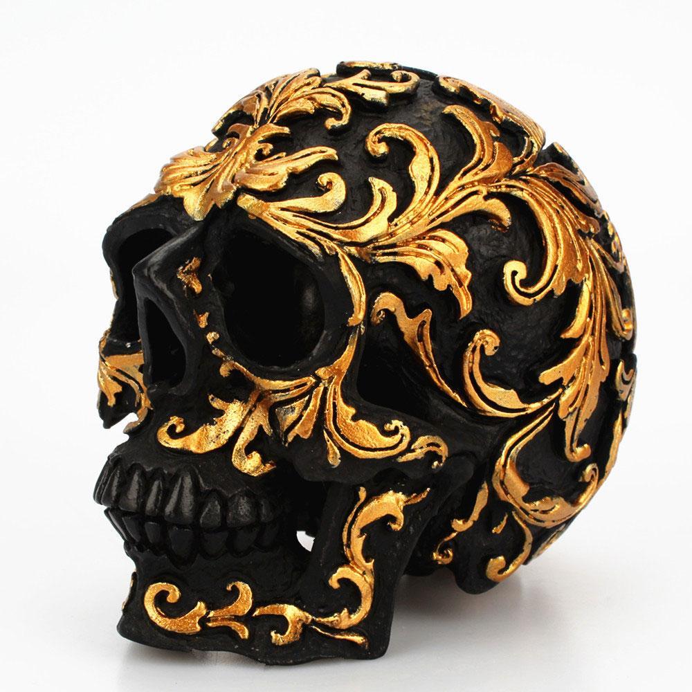 Escultura de calavera negra tallada en oro