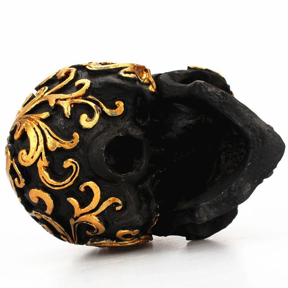 Scultura intagliata in oro con teschio nero